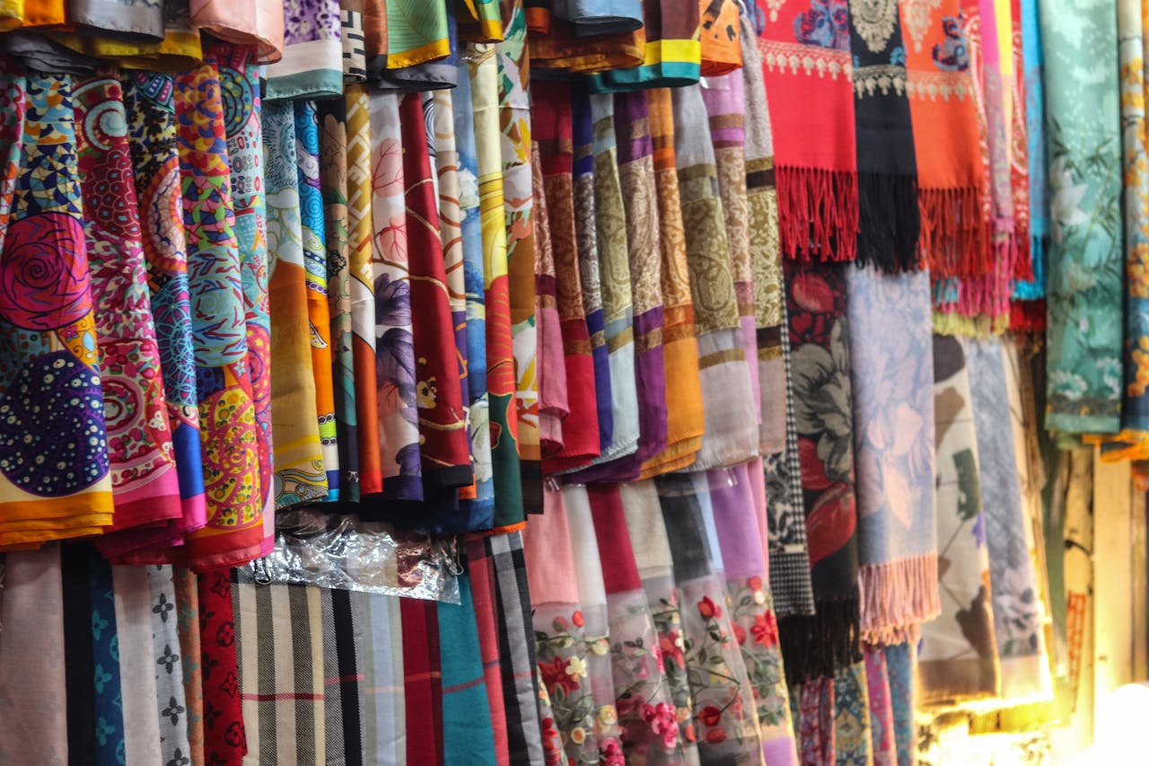 A vivid collection of silk shawls showcasing intricate patterns and bold colors on display.