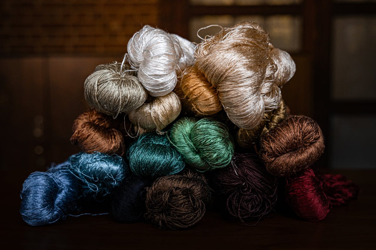 services-03 A vibrant collection of silk yarns stacked in a traditional Bursa workshop, showcasing rich textures and colors.